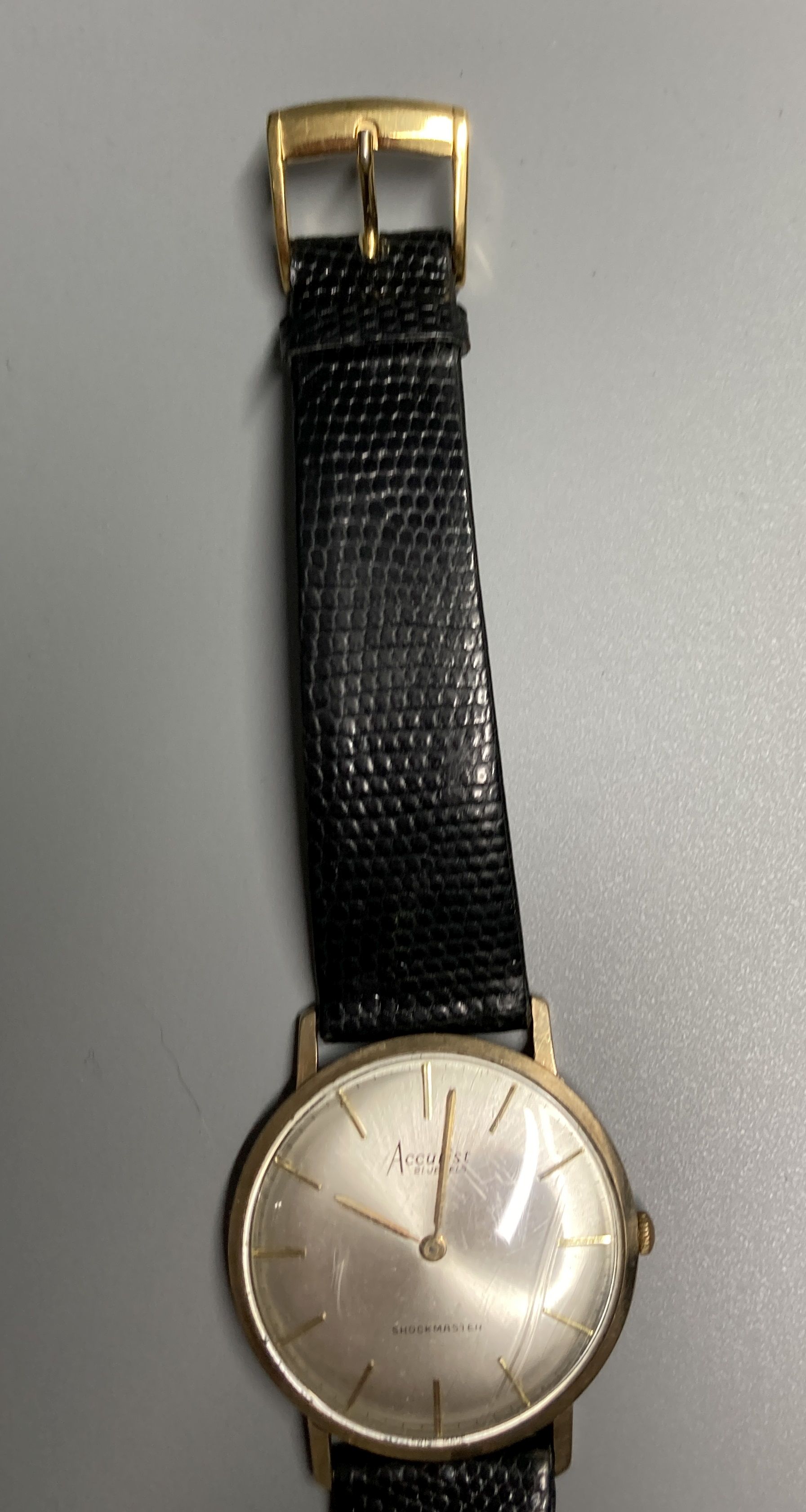 A gentlemans 9ct gold Accurist shockmaster manual wind wrist watch, on associated strap, gross 21.5 grams,